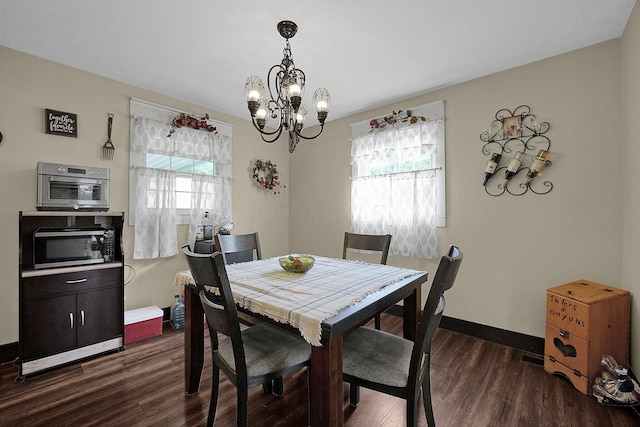 dining area featuring dark wood-type flooring and a chandelier