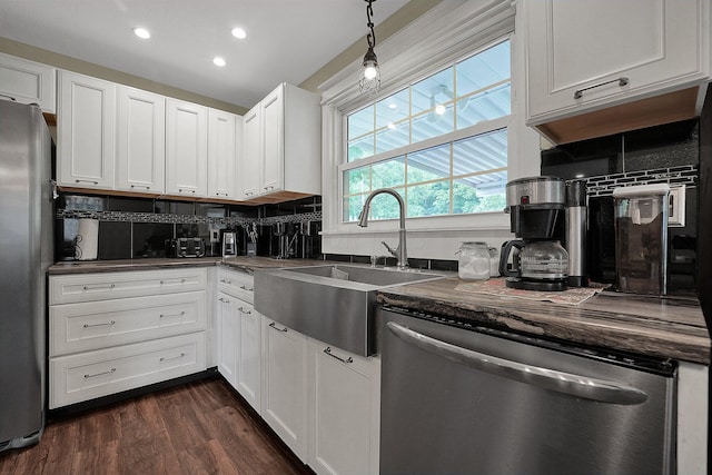 kitchen with stainless steel appliances, white cabinetry, tasteful backsplash, and sink