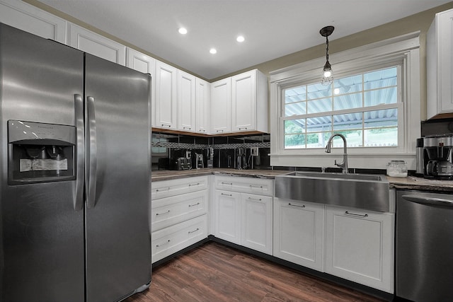 kitchen featuring white cabinetry, sink, hanging light fixtures, stainless steel appliances, and dark hardwood / wood-style floors