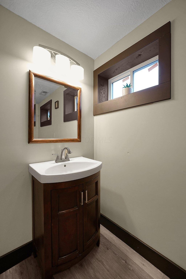 bathroom featuring vanity, hardwood / wood-style floors, and a textured ceiling