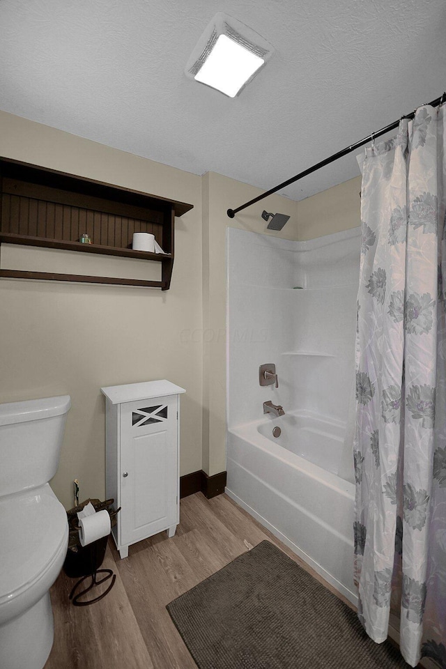 bathroom featuring shower / bath combination with curtain, hardwood / wood-style flooring, and toilet