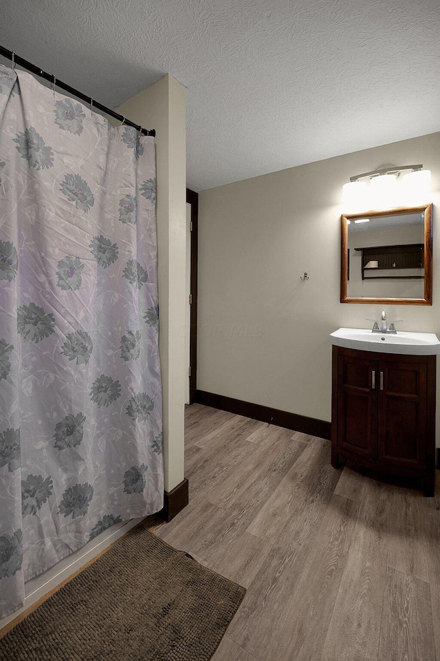 bathroom with vanity, a textured ceiling, and hardwood / wood-style flooring