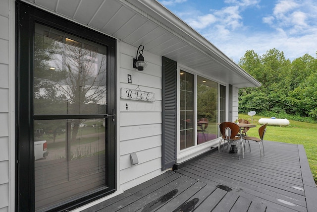 wooden terrace featuring a lawn