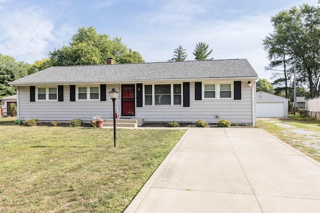 ranch-style home with a garage, an outbuilding, and a front lawn