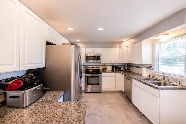 kitchen featuring appliances with stainless steel finishes, white cabinetry, and sink