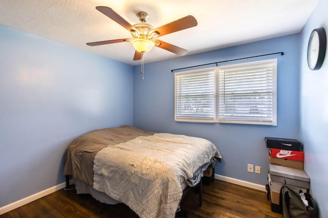 bedroom featuring ceiling fan, dark wood-type flooring, and a textured ceiling