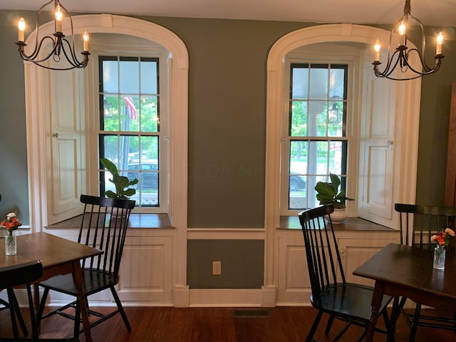 dining space with a notable chandelier and dark hardwood / wood-style floors