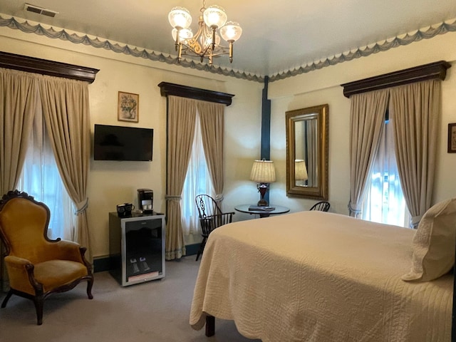 carpeted bedroom featuring an inviting chandelier