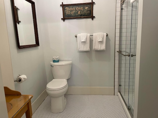 bathroom with toilet, a shower with door, vanity, and tile patterned flooring