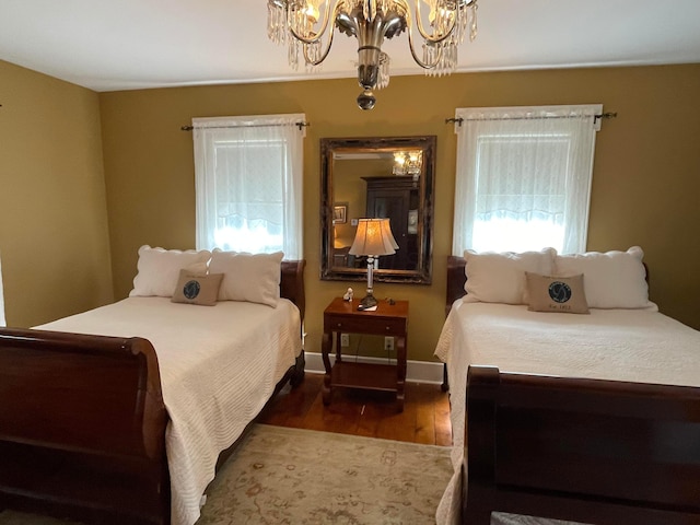 bedroom featuring an inviting chandelier and dark wood-type flooring