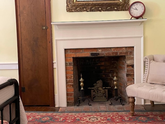 details with hardwood / wood-style floors and a brick fireplace