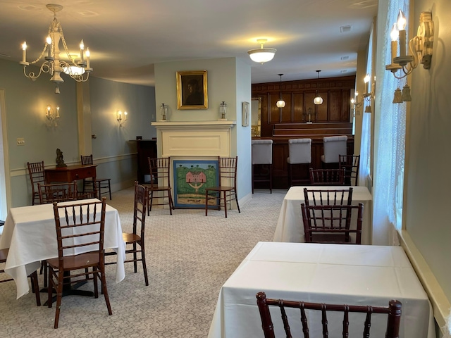 dining room featuring light carpet and a chandelier