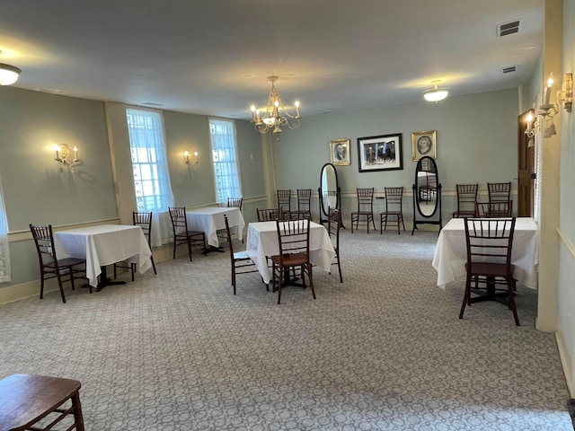 dining area with light carpet and a notable chandelier