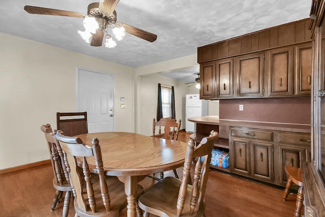 dining area featuring a textured ceiling and dark hardwood / wood-style flooring