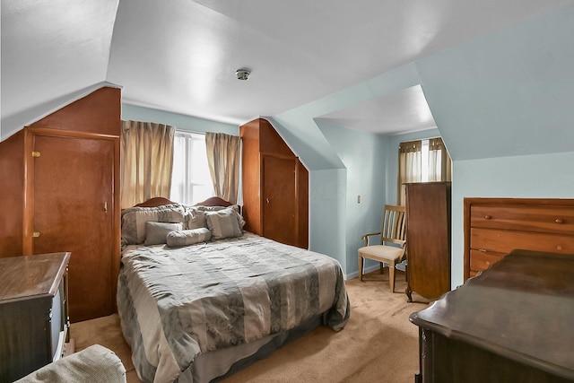 bedroom featuring light colored carpet and vaulted ceiling