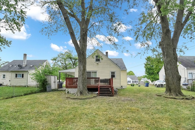 rear view of house with a lawn, a wooden deck, and a storage unit