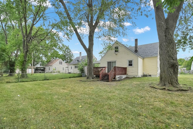 back of property featuring a lawn and a deck