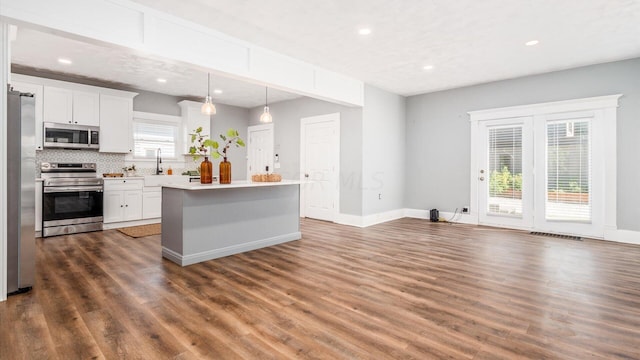 kitchen featuring a wealth of natural light, white cabinets, dark wood-type flooring, and appliances with stainless steel finishes