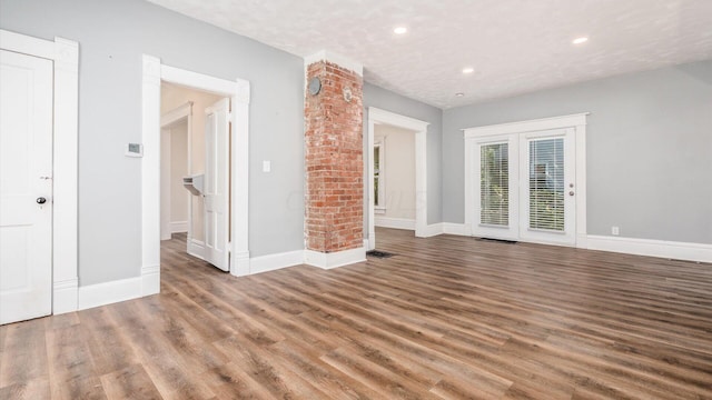 spare room with dark hardwood / wood-style floors and a textured ceiling