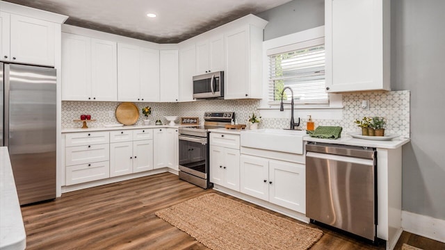 kitchen with decorative backsplash, dark hardwood / wood-style flooring, stainless steel appliances, and white cabinetry