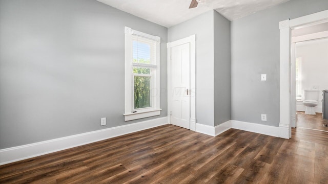 unfurnished bedroom featuring connected bathroom, ceiling fan, and dark hardwood / wood-style floors