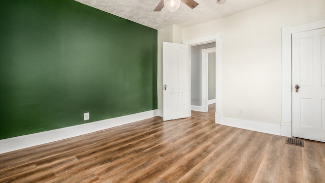 unfurnished bedroom with ceiling fan and wood-type flooring