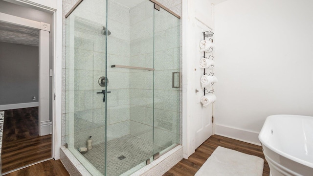 bathroom featuring wood-type flooring and separate shower and tub