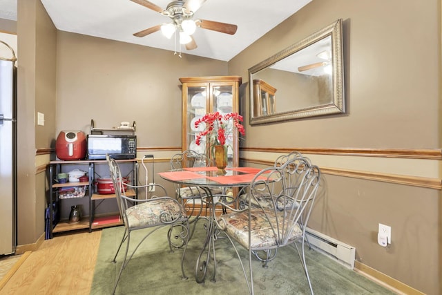 dining area with hardwood / wood-style flooring, vaulted ceiling, ceiling fan, and a baseboard heating unit