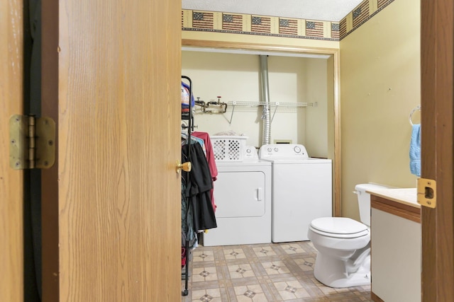 laundry room featuring a textured ceiling and washing machine and dryer