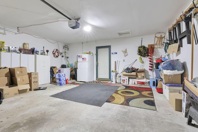 garage with white fridge and a garage door opener