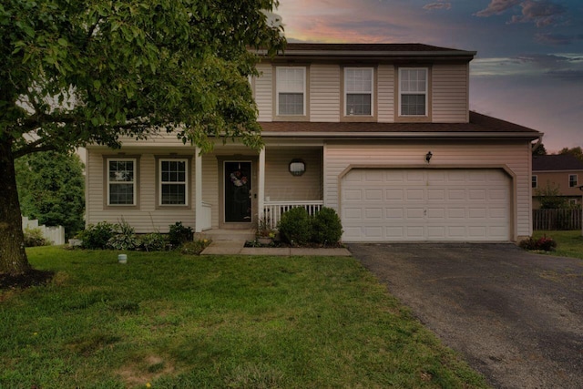 view of front of property with a garage, a yard, and covered porch