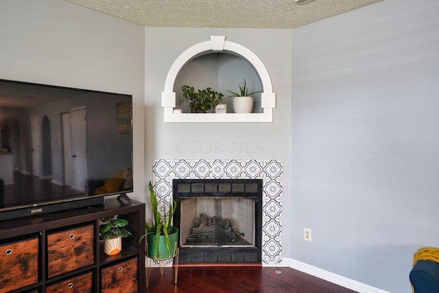 interior details with wood-type flooring, a textured ceiling, and a fireplace