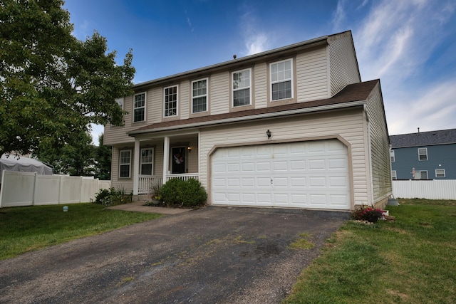 view of front of home with a garage, covered porch, and a front yard