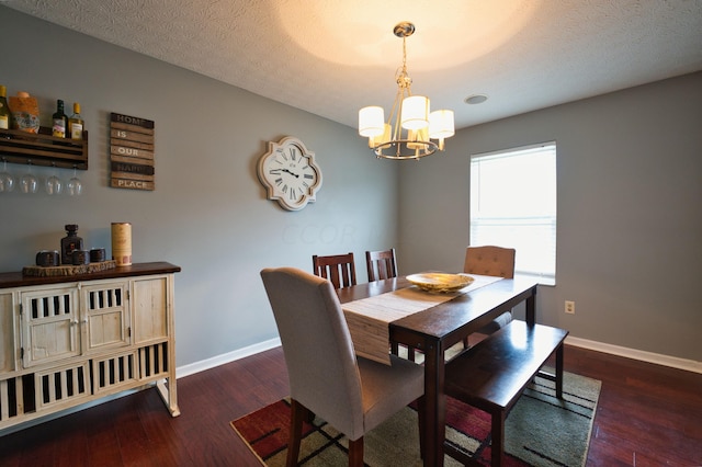 dining room featuring dark hardwood / wood-style floors, a textured ceiling, and a chandelier