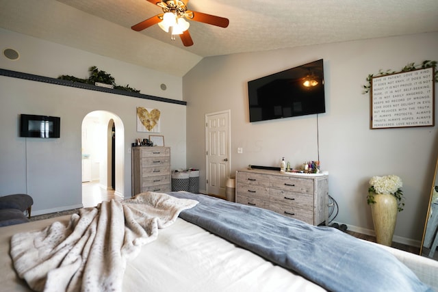 bedroom with vaulted ceiling, a textured ceiling, and ceiling fan