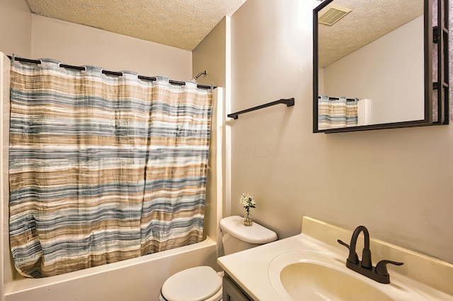 full bathroom with shower / tub combo with curtain, vanity, toilet, and a textured ceiling