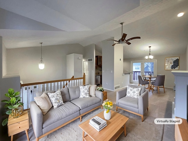 living room featuring ceiling fan with notable chandelier and vaulted ceiling