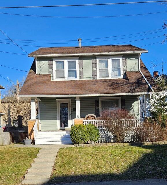 view of front of home with covered porch and a front lawn