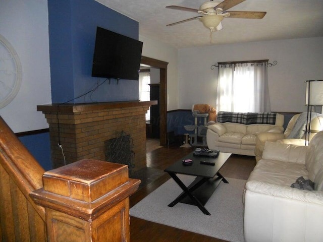 living room featuring a fireplace, dark hardwood / wood-style floors, and ceiling fan