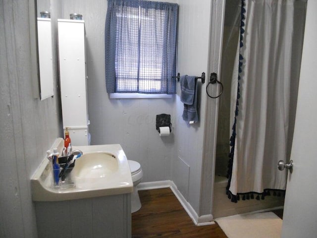 full bathroom featuring wood walls, toilet, shower / tub combo with curtain, vanity, and hardwood / wood-style flooring