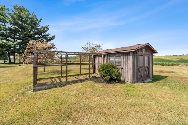 view of outdoor structure with a lawn and a rural view