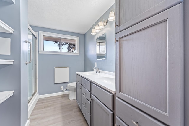 bathroom featuring walk in shower, radiator, a textured ceiling, hardwood / wood-style floors, and toilet