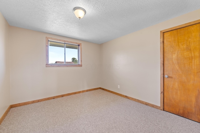 carpeted spare room featuring a textured ceiling