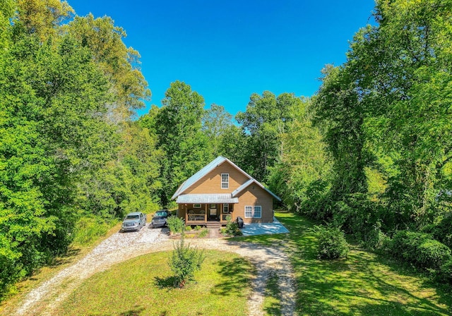 rear view of property featuring a lawn and a porch