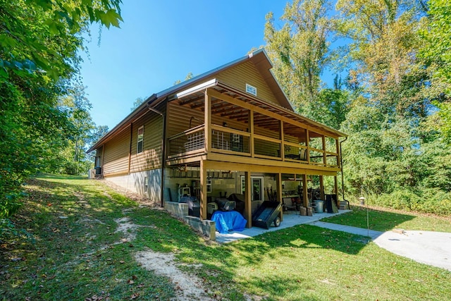 rear view of property featuring a patio area, a yard, and a deck