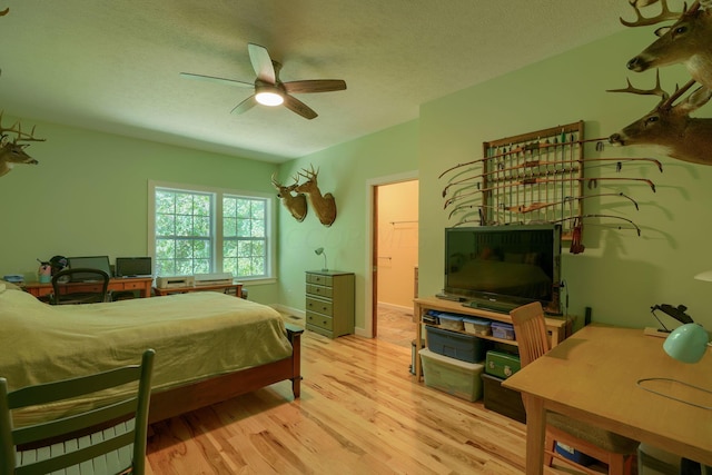 bedroom featuring ceiling fan, light hardwood / wood-style flooring, and a textured ceiling