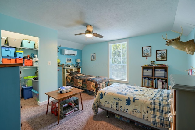 bedroom with carpet flooring, ceiling fan, an AC wall unit, a textured ceiling, and lofted ceiling