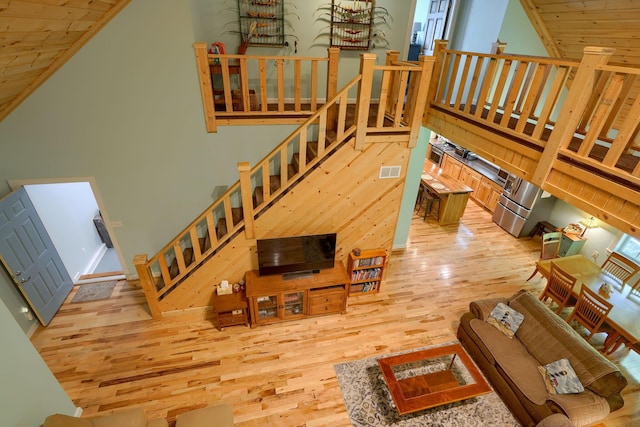 living room featuring a high ceiling and light hardwood / wood-style flooring