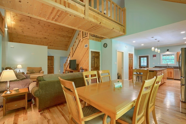 dining space with a chandelier, light hardwood / wood-style floors, high vaulted ceiling, and wooden ceiling