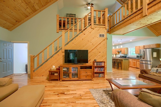 living room with light hardwood / wood-style floors, wood ceiling, and high vaulted ceiling